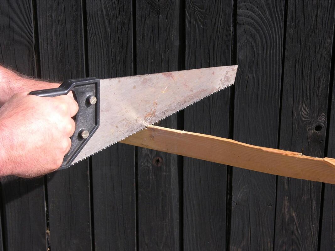 worker using a handsaw